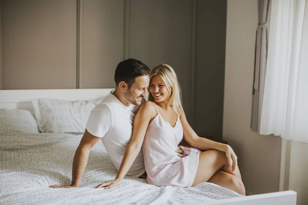 Amorosos amantes abraçando na cama em casa — Fotografia de Stock