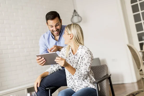 Young happy couple surfing on the web  on digital tablet at home — Stock Photo, Image