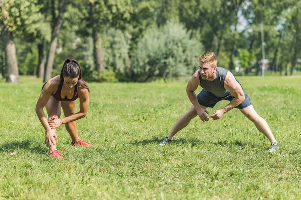 Fiatal pár, amelynek gyakorlása a parkban — Stock Fotó