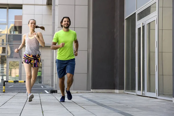 Pareja joven corriendo en la ciudad — Foto de Stock