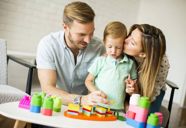 Piccolo ragazzo giocare giocattoli con madre e padre a casa — Foto Stock