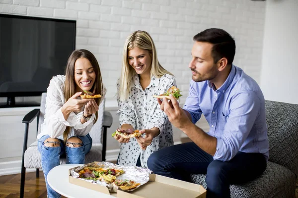 Giovani amici che mangiano pizza in camera — Foto Stock