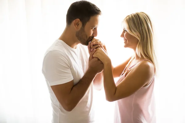 Mooie jonge paar staan bij het raam — Stockfoto