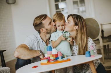 Küçük çocuk annesi ve babası evde oyuncaklarla oynamak