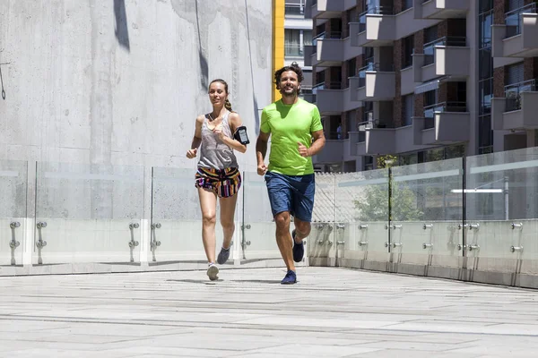 Pareja joven corriendo en la ciudad — Foto de Stock