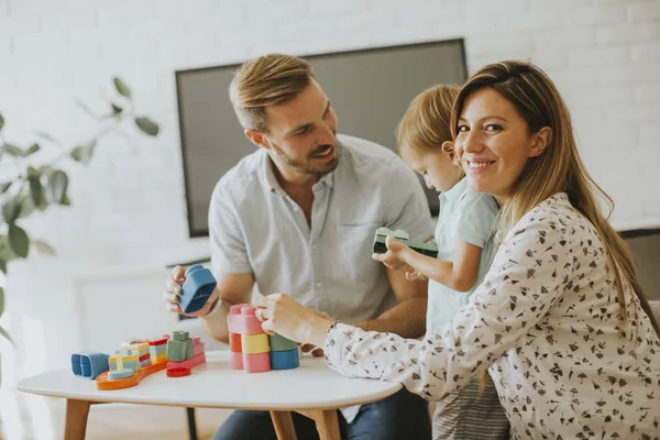 Küçük çocuk annesi ve babası evde oyuncaklarla oynamak