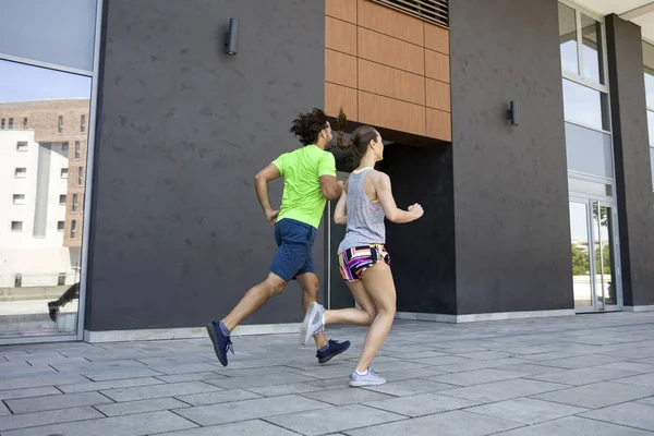 Pareja joven corriendo en la ciudad — Foto de Stock