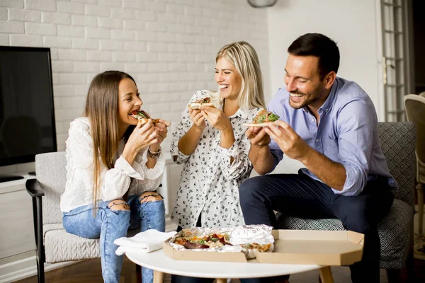 Przyjaciele jedzący pizzę w domu — Zdjęcie stockowe