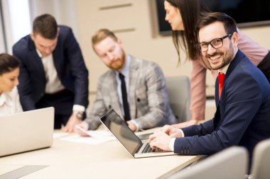 Genç iş adamları ofiste birlikte çalışıyorlar.