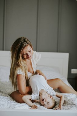 Yatağa küçük çocuk ile oynarken annesi