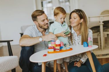 Küçük çocuk annesi ve babası evde oyuncaklarla oynamak