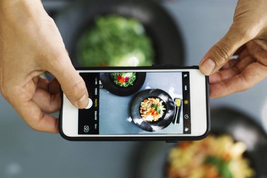 Restoranda yemek fotoğraf çekmek için cep telefonu kullanan insanların Üstten Görünüm