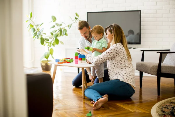 Pequeño niño jugando juguetes con la madre y el padre en casa — Foto de Stock