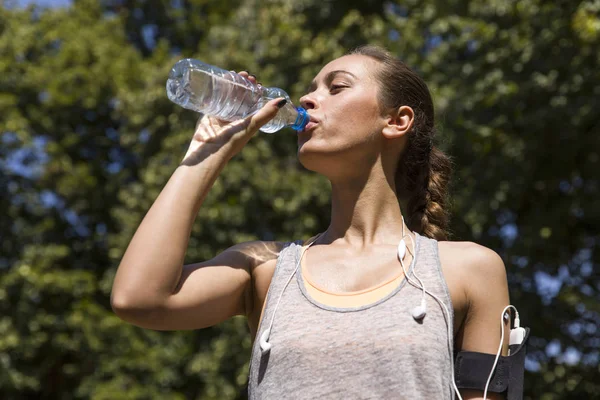 Mulher muito jovem bebendo água durante o exercício — Fotografia de Stock