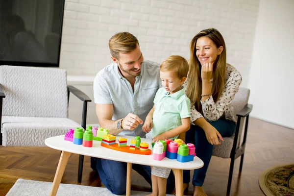 Pequeño niño jugando juguetes con la madre y el padre en casa — Foto de Stock