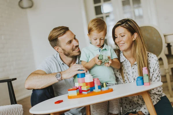 Piccolo ragazzo giocare giocattoli con madre e padre a casa — Foto Stock