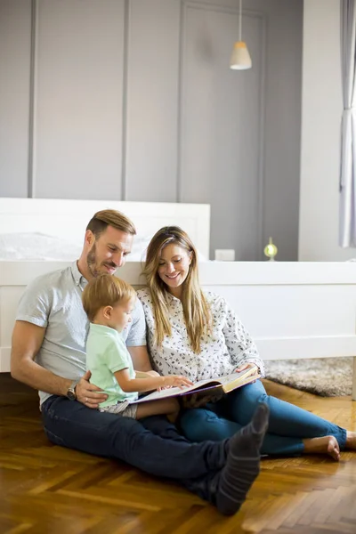 Junge Eltern lesen einem kleinen Jungen das Buch vor — Stockfoto