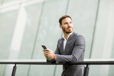 Genç işadamı cep telefonu kullanıyor. 