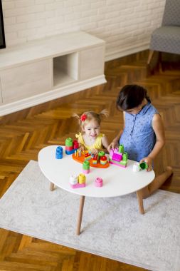 Odada oyuncaklarla oynayan iki küçük kız.