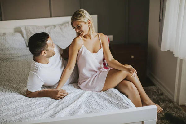 Gli amanti affettuosi che si abbracciano sul letto a casa — Foto Stock