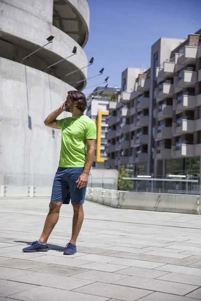 Stilig ung man använda mobiltelefon under träningen — Stockfoto