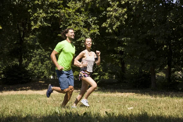 Jovem casal correndo na natureza — Fotografia de Stock