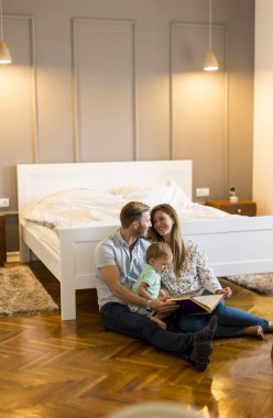 Mutlu genç aile yerde kitapla