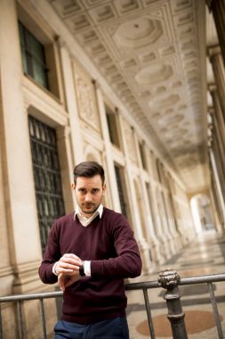 Yakışıklı adam rahat kıyafetler için beklerken zamanı denetleme