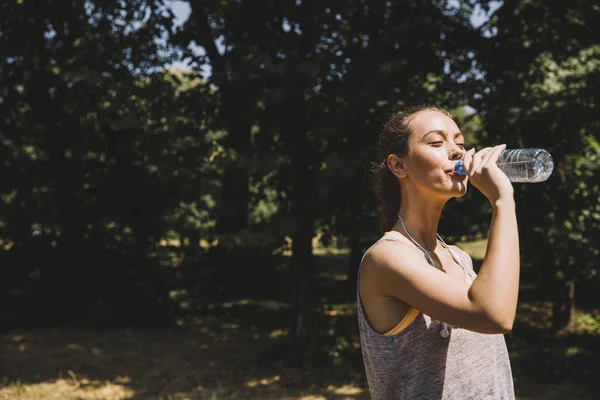 Genç ve güzel kadın içme suyu egzersiz sırasında