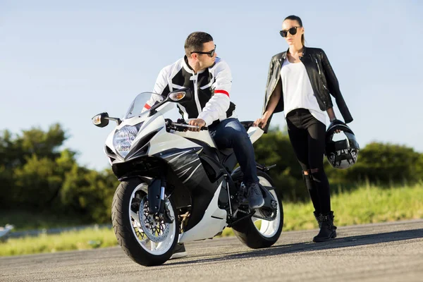 Genç adam ve bir kadın bir motosiklet üzerinde