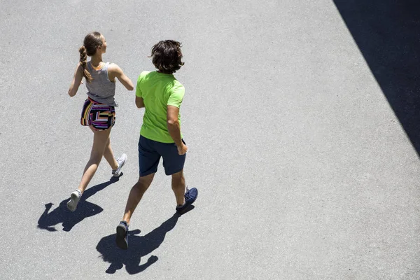 Hombre guapo y hermosa mujer corriendo juntos en la calle —  Fotos de Stock