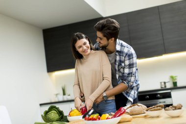 Genç çift modern mutfakta eğleniyor.