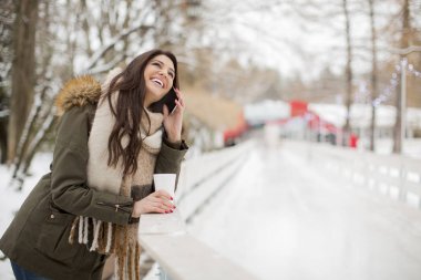 Parkta telefon kullanan genç kadın 