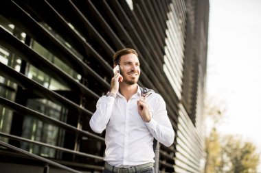 Mutlu gülümseyen kentsel işadamı Smartphone kullanarak