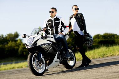 Genç adam ve bir kadın bir motosiklet üzerinde