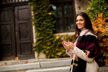 Cep telefonu kullanan gülümseyen kadın. 