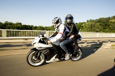 Genç adam ve bir kadın bir motosiklet üzerinde