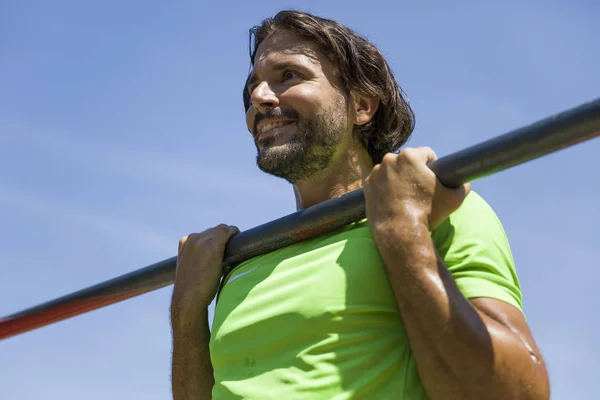 Uomo che fa pull up sulla barra orizzontale all'aperto — Foto Stock