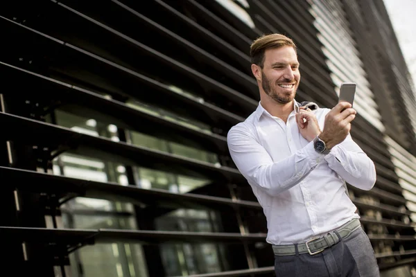 Mutlu gülümseyen kentsel işadamı Smartphone kullanarak