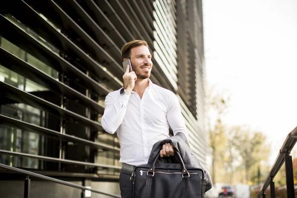 Счастливый улыбчивый городской бизнесмен с помощью смартфона — стоковое фото