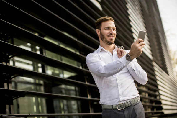 Feliz hombre de negocios urbano sonriente usando teléfono inteligente — Foto de Stock