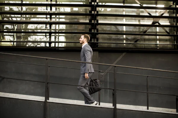 Бизнесмен в костюме с кожаной сумочкой идет на работу — стоковое фото