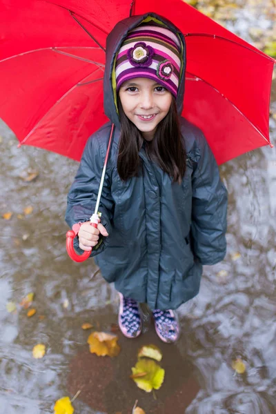 Маленька дівчинка з парасолькою в дощовий день — стокове фото