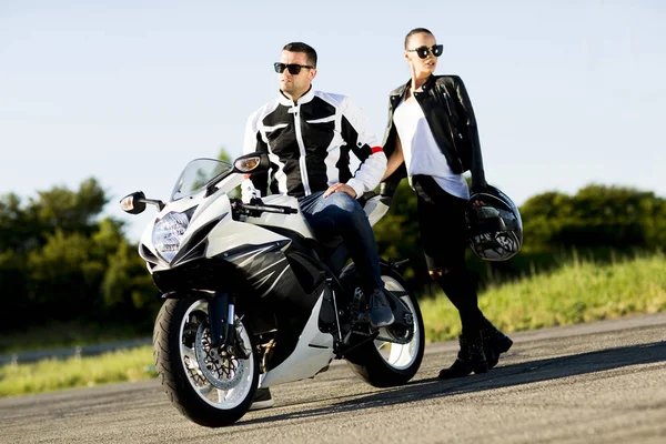 Jonge man en een vrouw op een motorfiets — Stockfoto