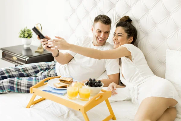 Jovem casal feliz tomando café da manhã — Fotografia de Stock