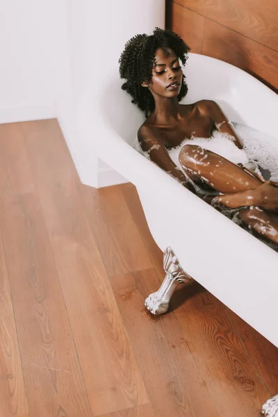 Jeune afro américaine jeune femme couchée dans le bain — Photo