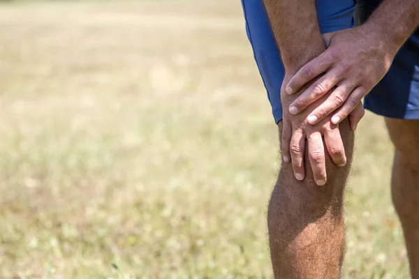 El hombre sostiene su rodilla que duele — Foto de Stock