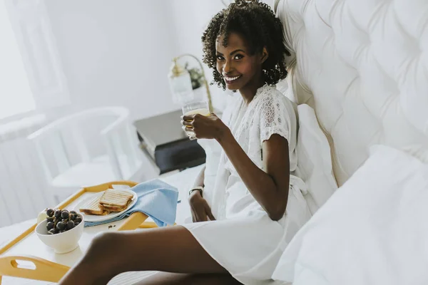 Sorrindo afro-americana tendo um café da manhã relaxante — Fotografia de Stock