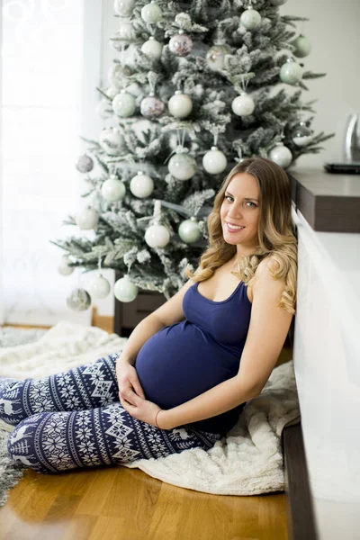 Bella giovane donna incinta vicino all'albero di Natale — Foto Stock