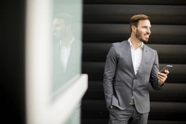 Ευτυχισμένος χαμογελώντας αστικών επιχειρηματίας χρησιμοποιώντας smartphone — Φωτογραφία Αρχείου